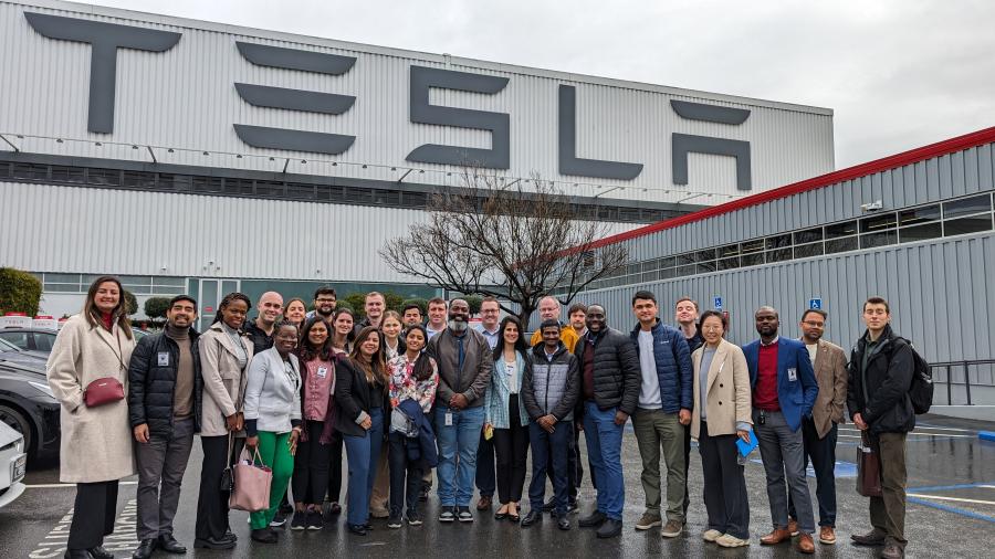 MBA Societal Shifts participants pose in front of Tesla