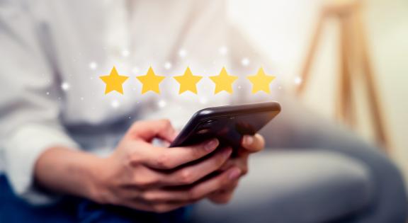 person holding smartphone with review star images