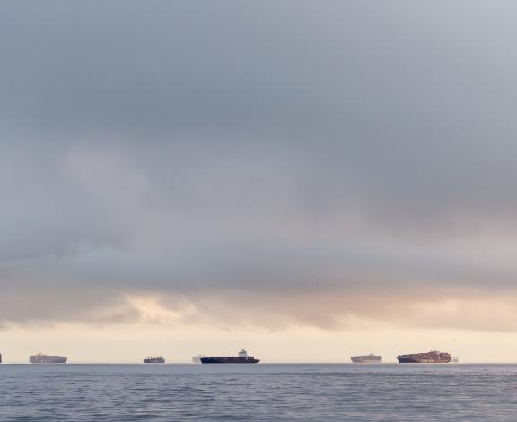 Container ships sit at anchor off the Port of Los Angeles, California at dawn on 10th November 2021