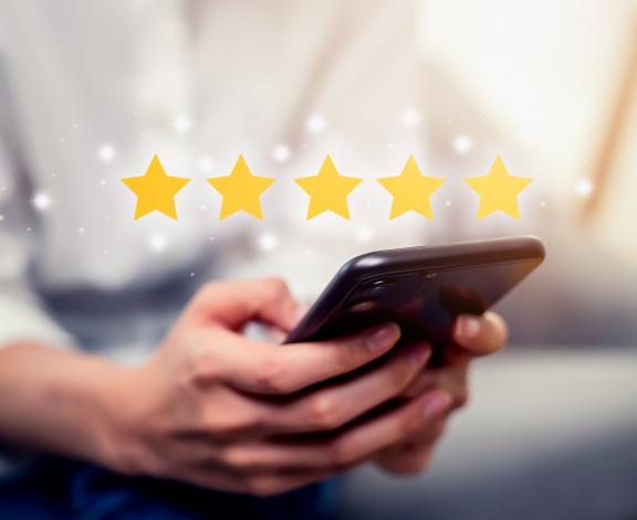 person holding smartphone with review star images