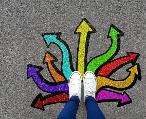 person standing on pavement with painted arrows