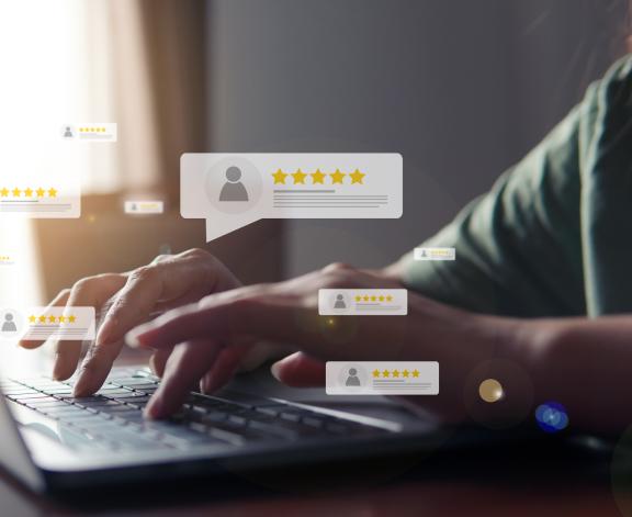 person typing on a computer with online review graphics