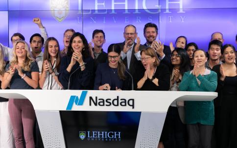 Samantha Dewalt, managing director of the Lehigh@NasdaqCenter, rings the opening bell of the Nasdaq Market, flanked by Lehigh students. 