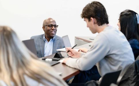 Ozias Moore, associate professor of management, interacts with students during his Leadership in Organizations course